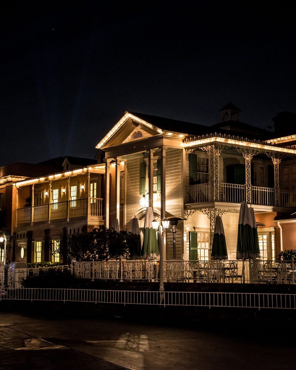 A columned entry and veranda lit warm at night