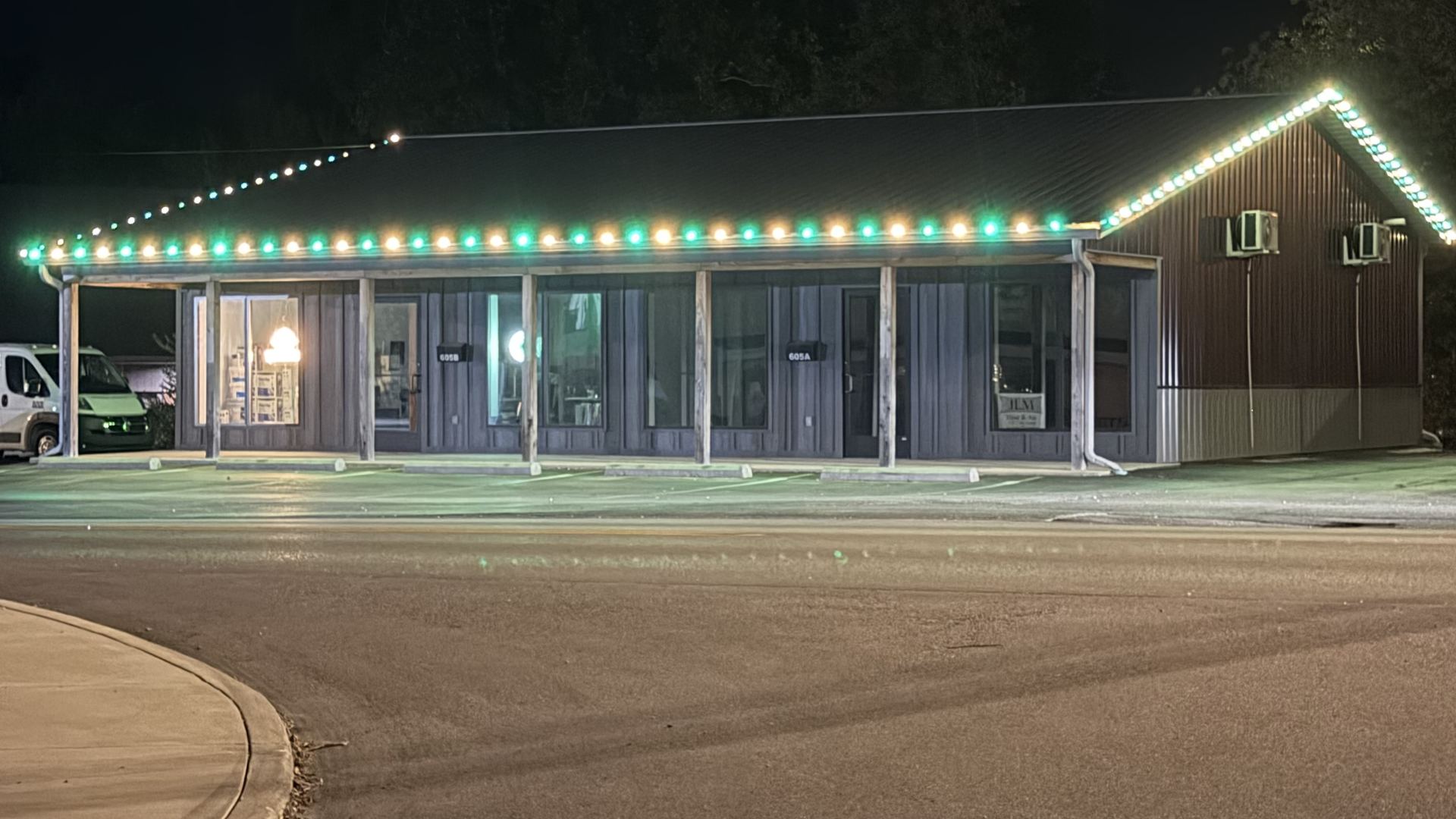 Our office building in Sheridan at night, the roofline lit in green and warm white
